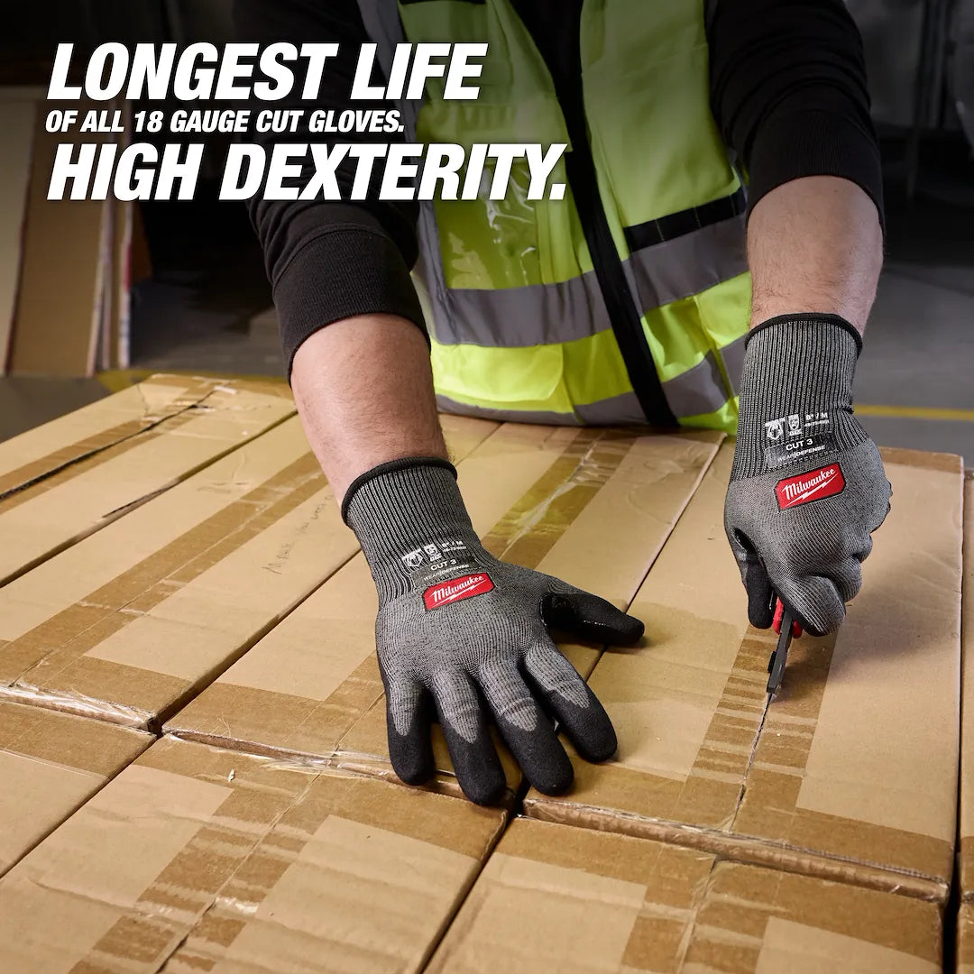 Hands wearing Milwaukee Cut Level 3 High Dexterity gloves cutting cardboard boxes