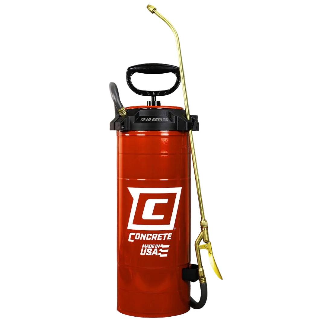 A red hand-pumped concrete mixer with a black handle and a brass spray wand, shown against a brushed gray metal background.
