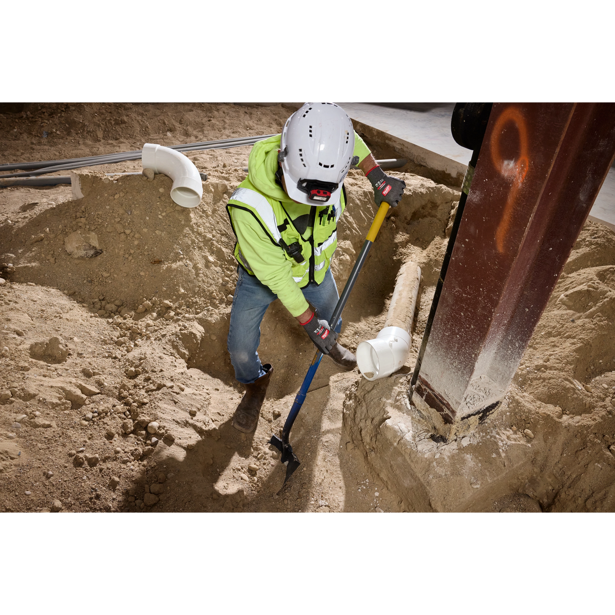 Worker digging while wearing Milwaukee Cut Level 5 High Dexterity gloves